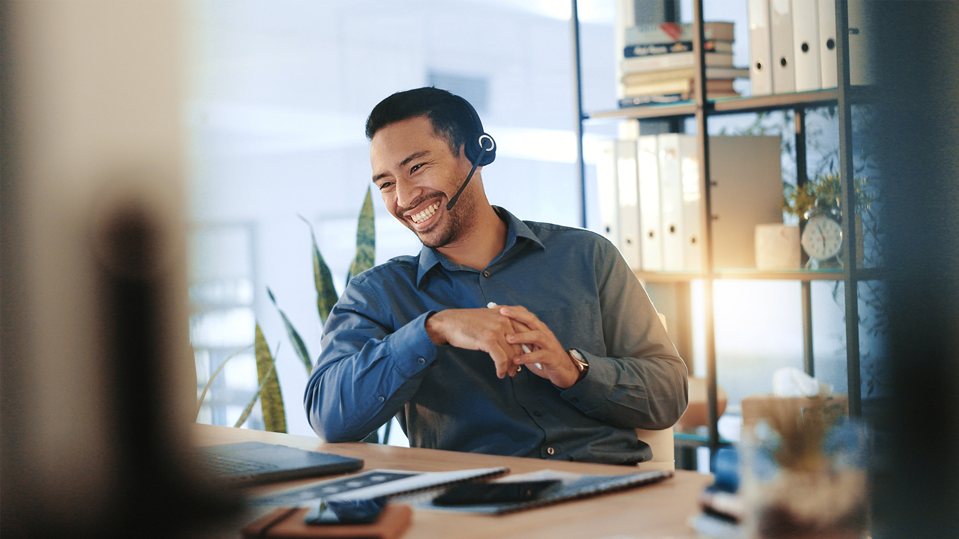 Lächelnder Berater mit Headset in modernem Büro.